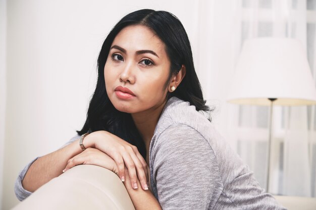 Het mooie Filipijnse vrouw ontspannen op zachte laag