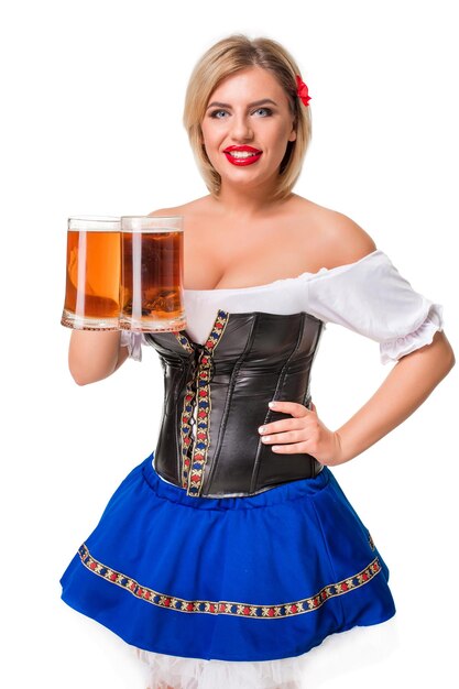 Het mooie jonge blonde meisje in dirndl drinkt uit de meest oktoberfest bierpul. Geïsoleerd op een witte achtergrond.