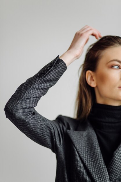 Het mooie maniervrouw stellen met elegant kostuum