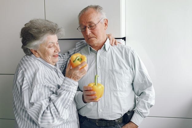 Het mooie oude paar bereidt voedsel in een keuken voor