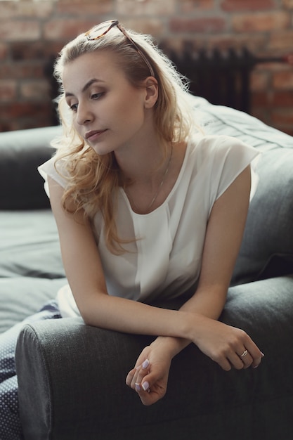 Gratis foto het mooie vrouw stellen in de bank, binnenlands huis