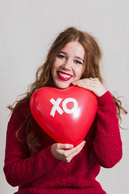 Gratis foto het mooie vrouw stellen met een hartballon