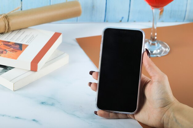 Het nemen van een zwarte smartphone in de hand op de tafel