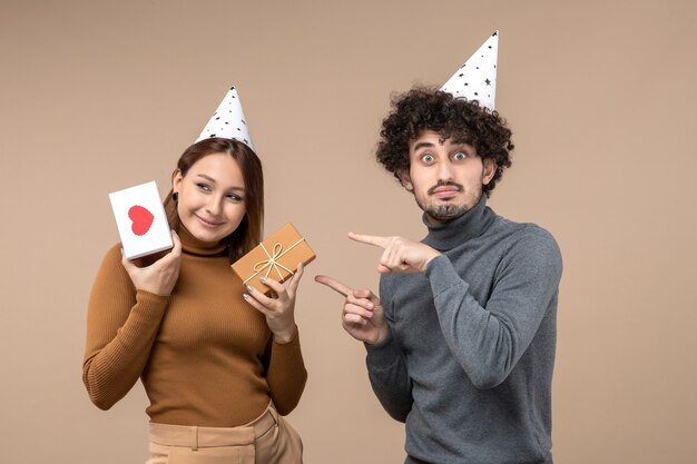 Het nieuwe jaarconcept met mooi jong paar draagt het emotionele meisje van de nieuwjaarshoed