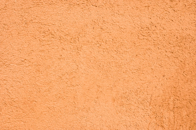 Het oranje close-up van de huismuur