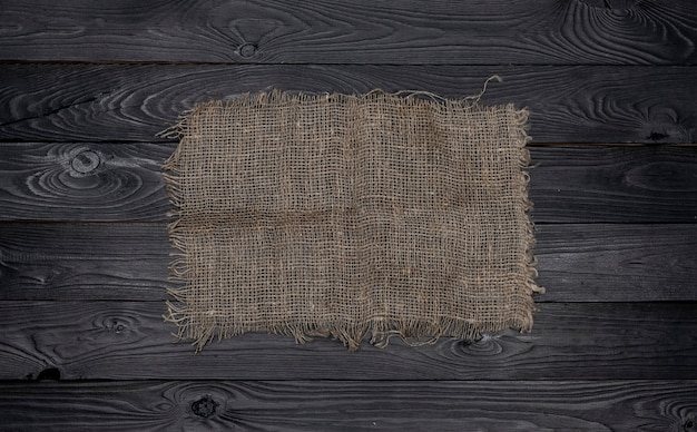 Het oude servet van de jutestof op zwarte houten achtergrond, hoogste mening
