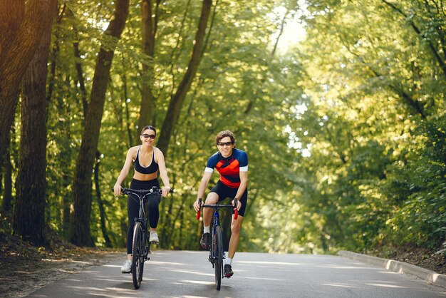 Het paar berijdende fietsen van sporten in de zomerbos