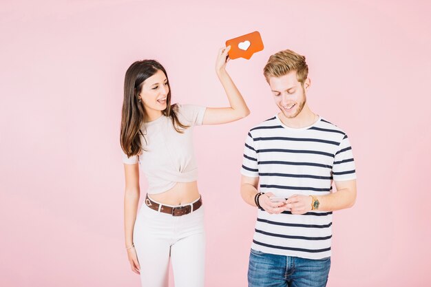 Het pictogram van de de holdingsliefde van de vrouw over het hoofd die van haar vriend smartphone gebruiken