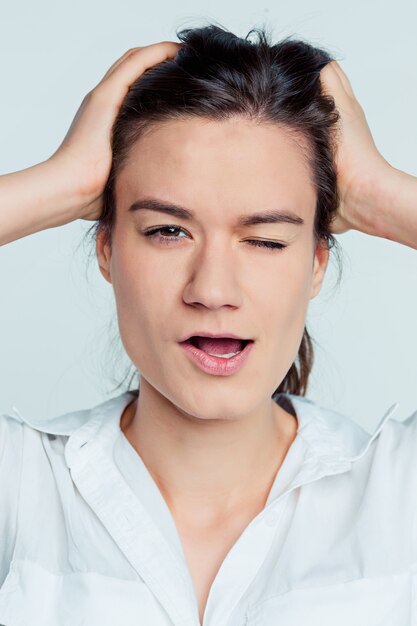 Het portret van de jonge vrouw met doordachte emoties op blauwe ruimte