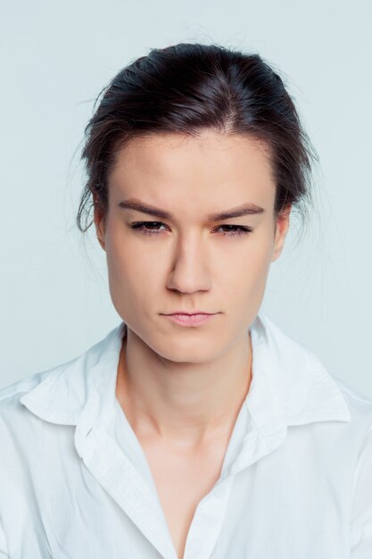 Het portret van de jonge vrouw met doordachte emoties op blauwe ruimte