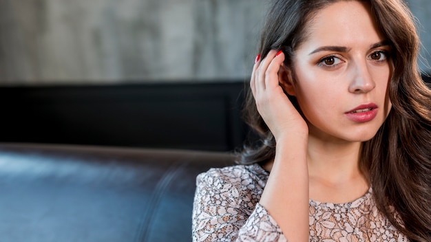 Het portret van een aantrekkelijke jonge vrouw met haar dient haar in