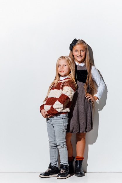 Het portret van schattige kleine meisjes in stijlvolle jeans kleding kijken camera studio