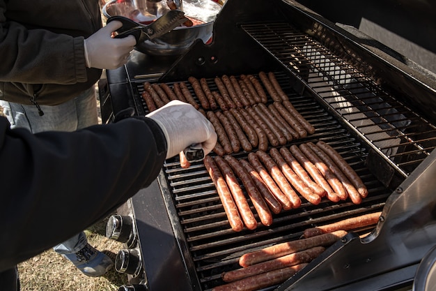 Gratis foto het proces van het grillen van jachtworsten in de natuur.