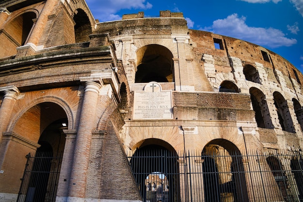 Gratis foto het romeinse colosseum met heldere blauwe lucht en wolken