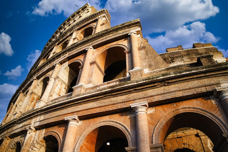 Gratis Foto het romeinse colosseum met heldere blauwe lucht en wolken