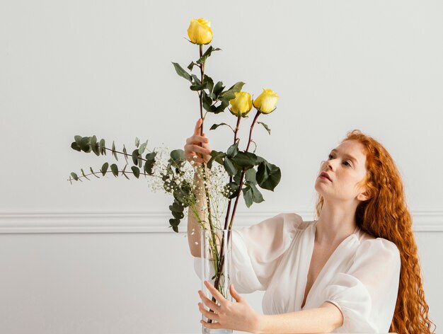 Het schitterende vrouw stellen met Lentebloemen