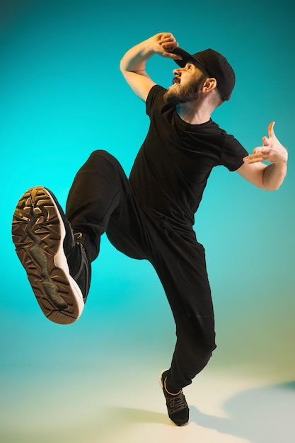 Gratis foto het silhouet van een hiphop mannelijke breakdancer die danst op een kleurrijke achtergrond