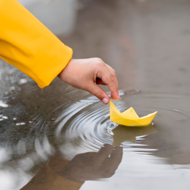 Het spelen van de jongen in water met een document bootclose-up