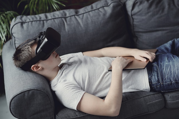 Het spelen van de jongen met VR-hoofdtelefoon thuis