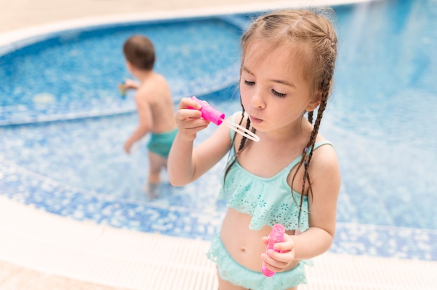 Gratis foto het spelen van het meisje met bellenventilator