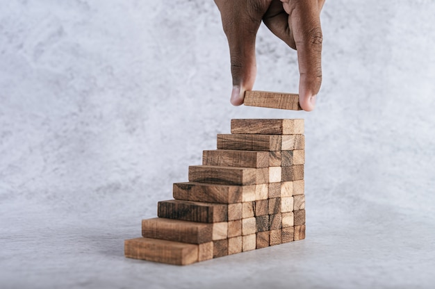Het stapelen van houten blokken loopt een risico bij het creëren van ideeën voor bedrijfsgroei.