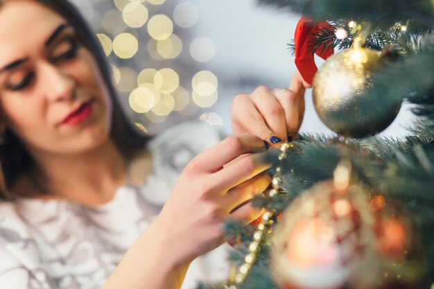 Het stijlvolle meisje versieren van een kerstboom
