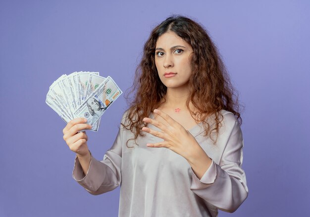 Het strikte jonge mooie contant geld van de meisjesholding en het tonen van vier geïsoleerd op blauwe muur