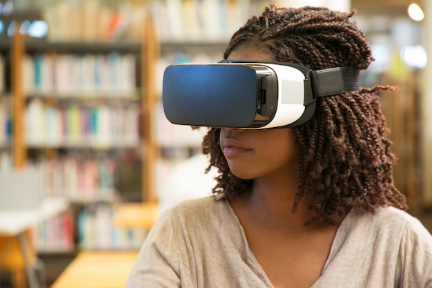 Het studentenmeisje dat van de zwarte VR-glazen voor het werk met behulp van