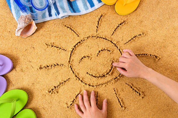 Het tekenen van een gelukkige zon op het strand