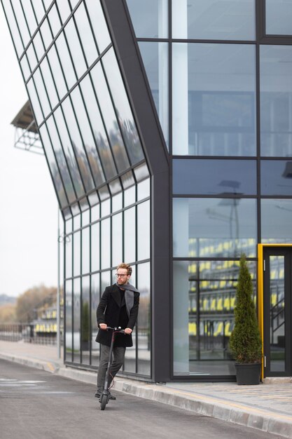 Het toevallige mannelijke stellen met een elektrische autoped