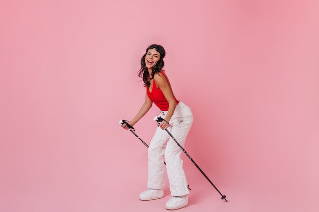 Het vrolijke jonge vrouw stellen met skistokken