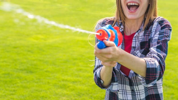 Het vrolijke meisje spelen met waterkanon