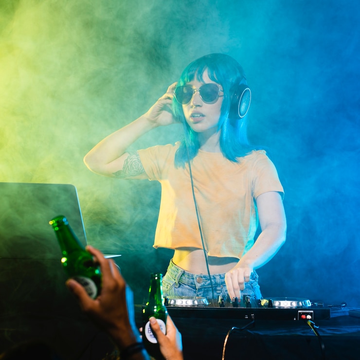 Gratis Foto het vrouwelijke dj mengen behandeld in kleurrijke rook en lichten