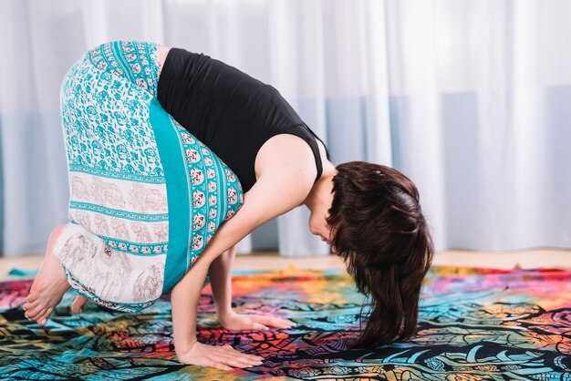 Het vrouwenwijfje die bakasana yoga doen stelt thuis