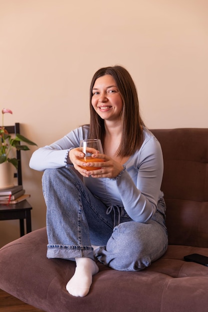 Het zijaanzicht van een mooie vrouw die naar de camera kijkt en thuis ontspant