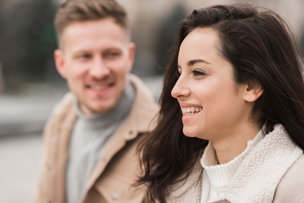 Het zijaanzicht van vrouw en defocused de mens in openlucht