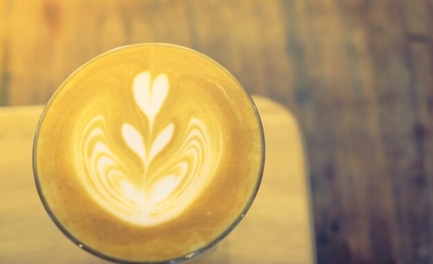 Hete latte kunst koffie op tafel (gefilterde afbeelding verwerkt vintage