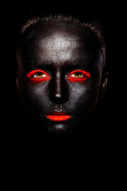 High fashion look.glamour fashion mooie zwarte Amerikaanse vrouw in zwart masker met oranje lichte make-up en oranje lippen
