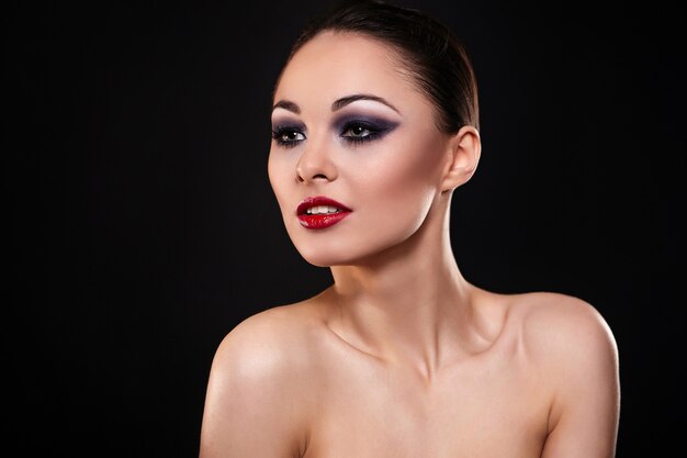 High fashion look.glamour mode portret van mooie sexy brunette meisje met lichte make-up en rode lippen op donker