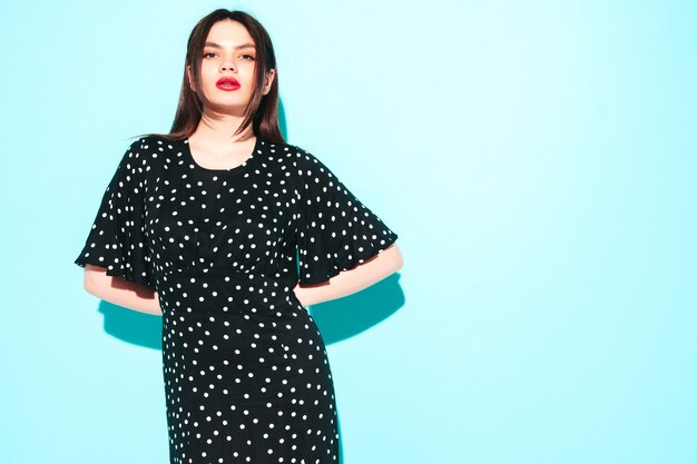 High fashion portret van jonge mooie brunette vrouw die mooie trendy zomerse polka-dot jurk draagt