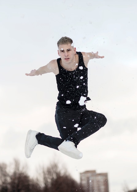 Gratis foto hiphopdanser het stellen met buiten sneeuw terwijl het dansen