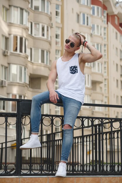 Hipster knappe blonde man man in stijlvolle zomer kleding in de straat