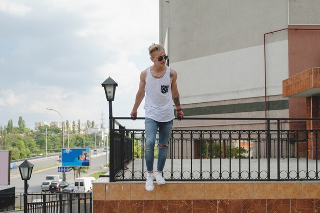 Hipster knappe blonde man man in stijlvolle zomer kleding in de straat