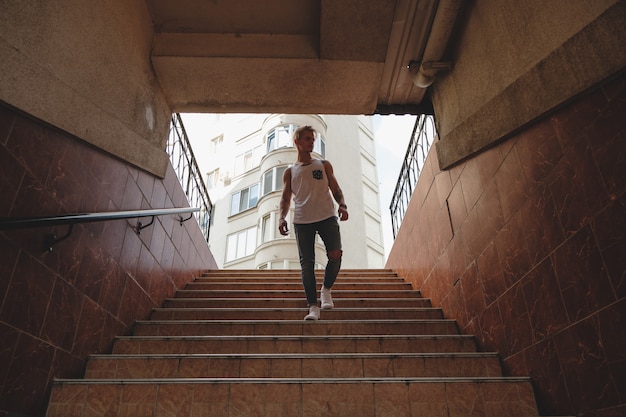 Hipster knappe blonde man man in stijlvolle zomer kleding in de straat