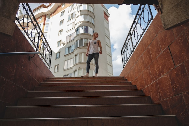 Hipster knappe blonde man man in stijlvolle zomer kleding in de straat