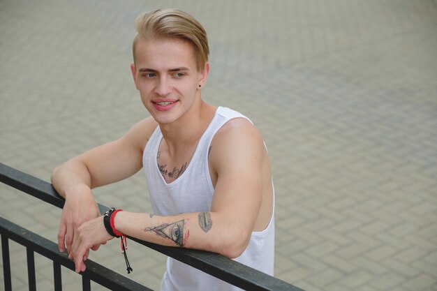 Hipster knappe blonde man man in stijlvolle zomer kleding in de straat