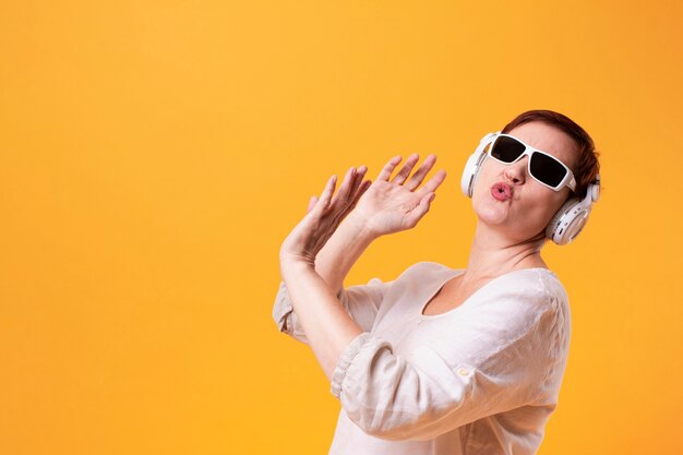 Hipster senior vrouw dansen en muziek luisteren