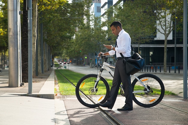 Hispanic Office Worker Met Fiets En Telefoon In Straat