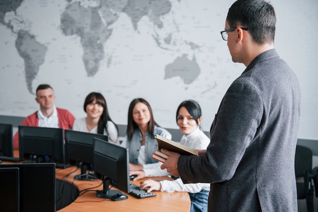 Hoe gaat het met je deals? Groep mensen op handelsconferentie in moderne klas overdag