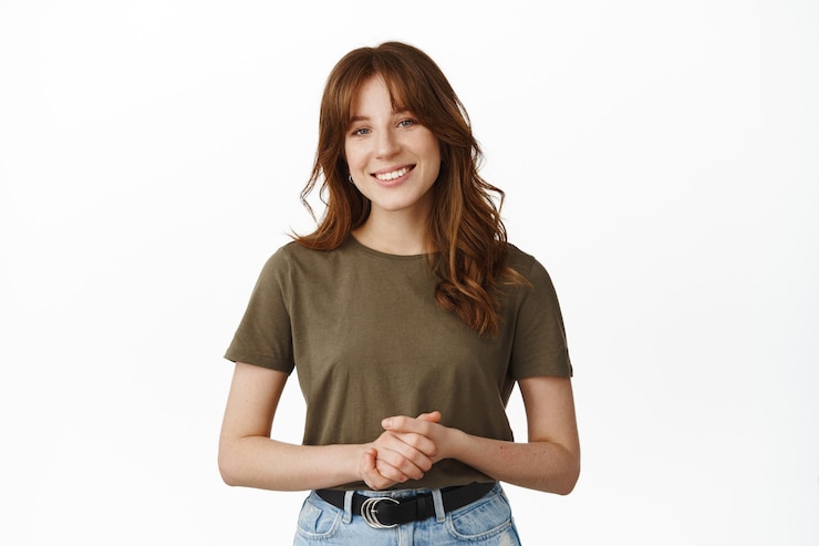 Gratis Foto hoe kan ik je helpen. glimlachende vriendelijke vrouw die in een aangename formele pose staat, emoties bij elkaar houdt, klaar om hulp of hulp te bieden, staande op wit.